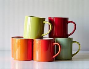 Stack of colorful mugs with custom printing